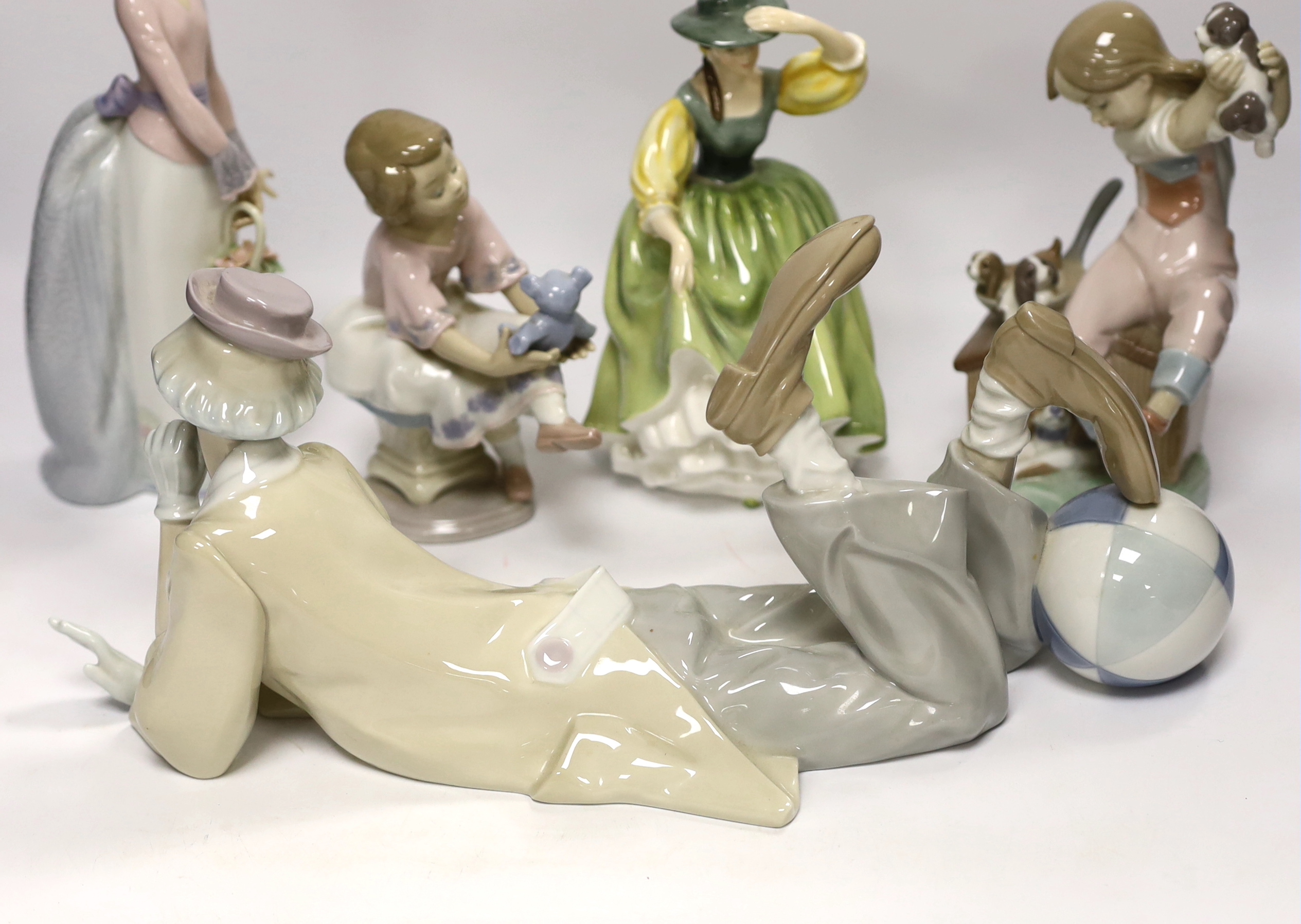 A Lladro recumbent clown, three smaller Lladro figures and a Royal Doulton Buttercup figure, clown 37.7cm wide (5)